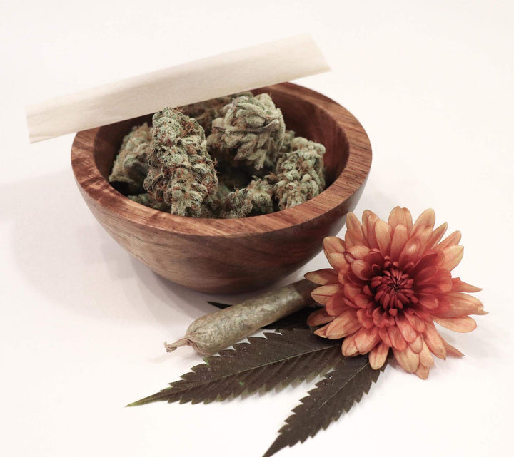 Hemp flower in a bowl with hemp pre-roll joint and flower decor
