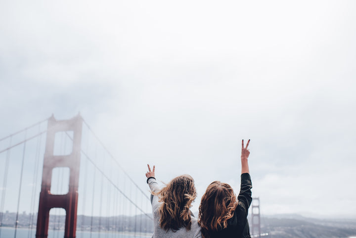 golden gate bridge with two girls making peace signs can CBD make me happier